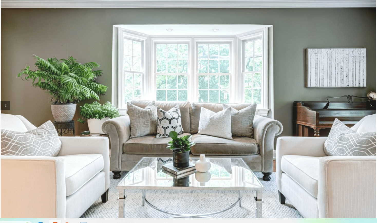 Staged living room interior with sofa, chairs, plants, coffee table, piano, and natural light, showcasing home staging.