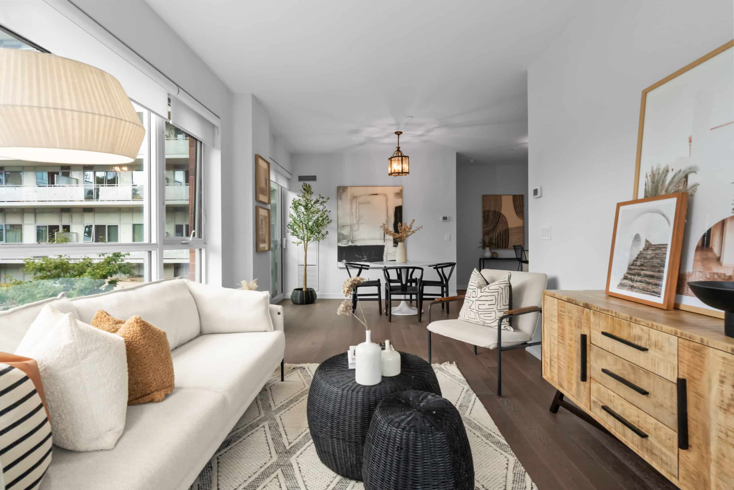 Staged living room showcasing a modern interior design with a white sofa, dining area, and stylish decor for real estate appeal.